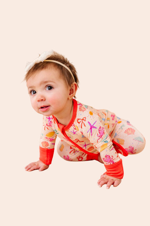 Baby in a colorful outfit crawling on a beige background